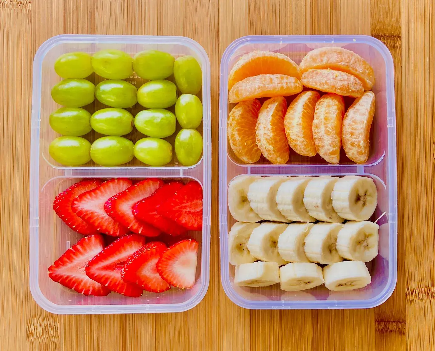 Fruits frais découpés en portions : raisins, fraises, clémentines et bananes